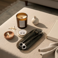 A fun-size candle next to a 3-piece accessory set including a candle snuffer, wick trimmer, and candle tray, with the KEO brand visible on the tray.